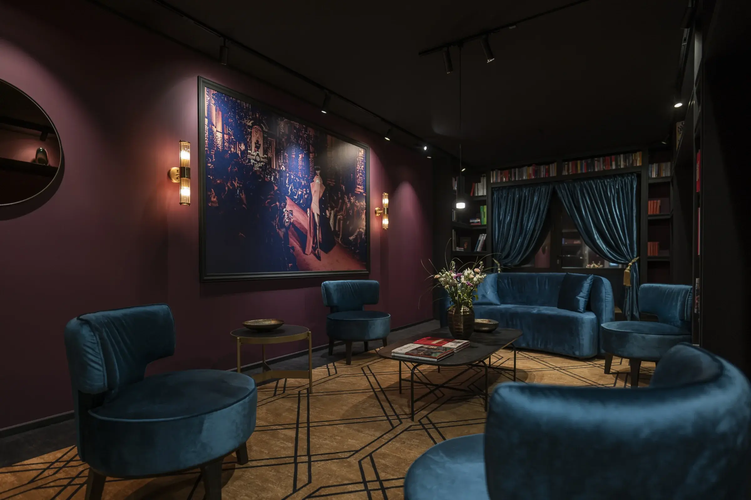 Leipzig Suites Lobby — Samtsessel, großes Kunstwerk und Bordeaux-Wand als Rückzugsort
